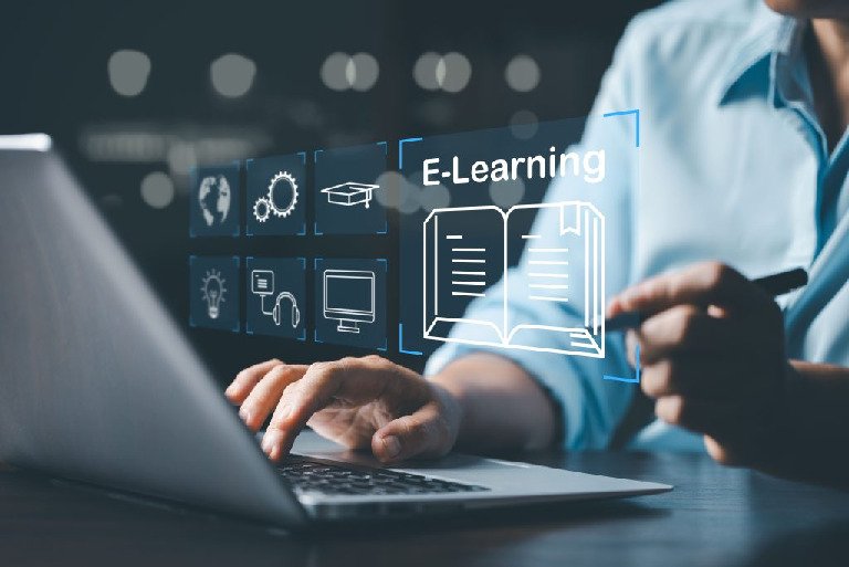 Persona escribiendo en un portátil con icono de graduación en pantalla